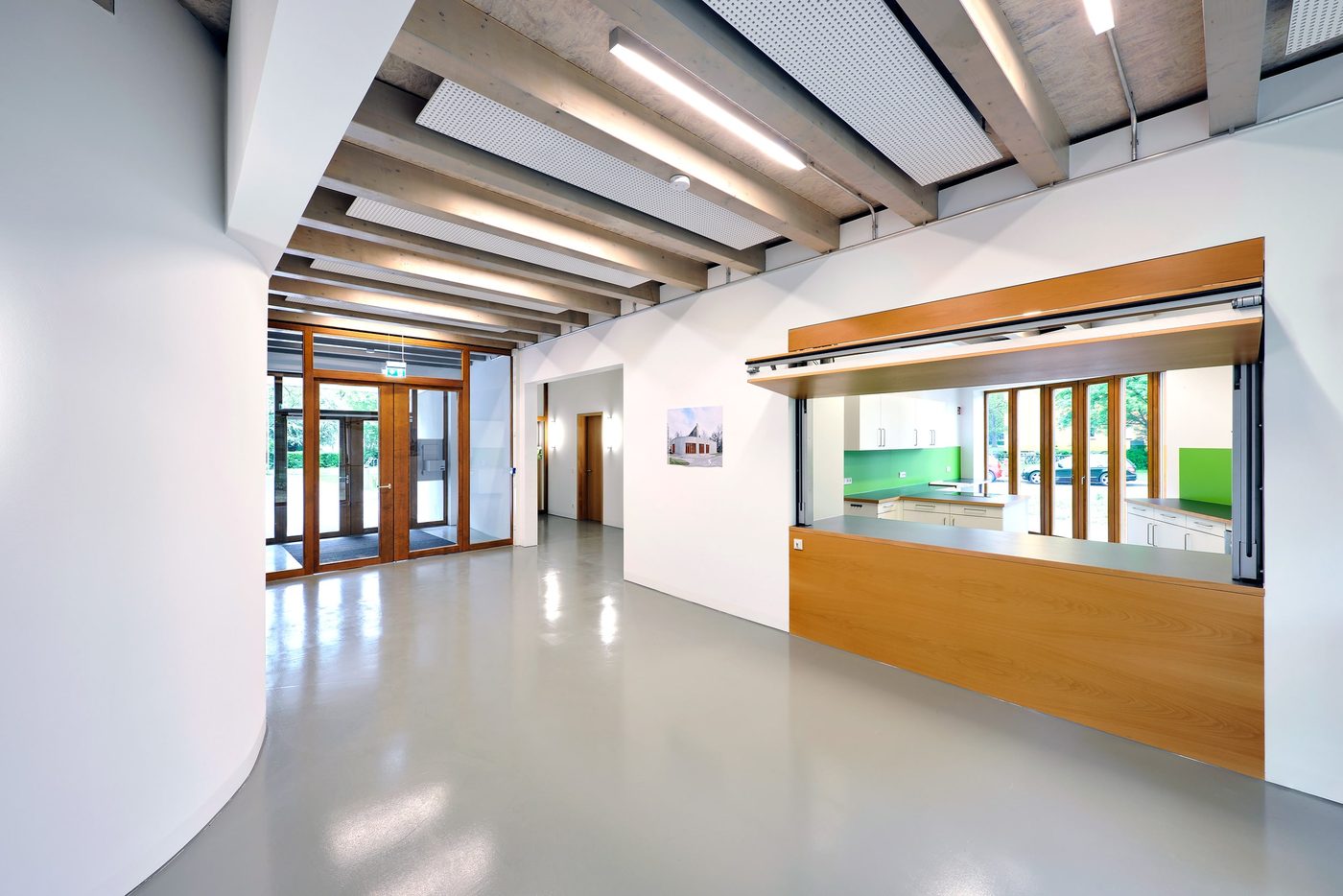 Foyer mit Durchreiche und geschwungener weißer Wand